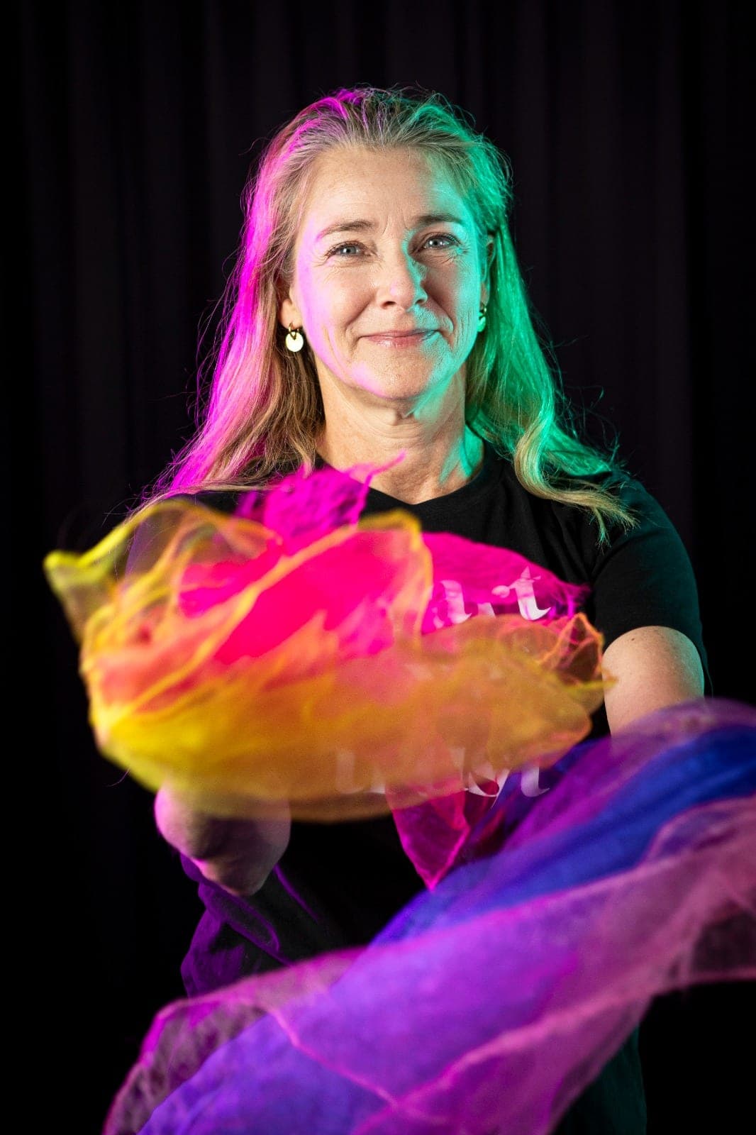 Helga Verrijp zwaait met een oranje en roze chiffon sjaal