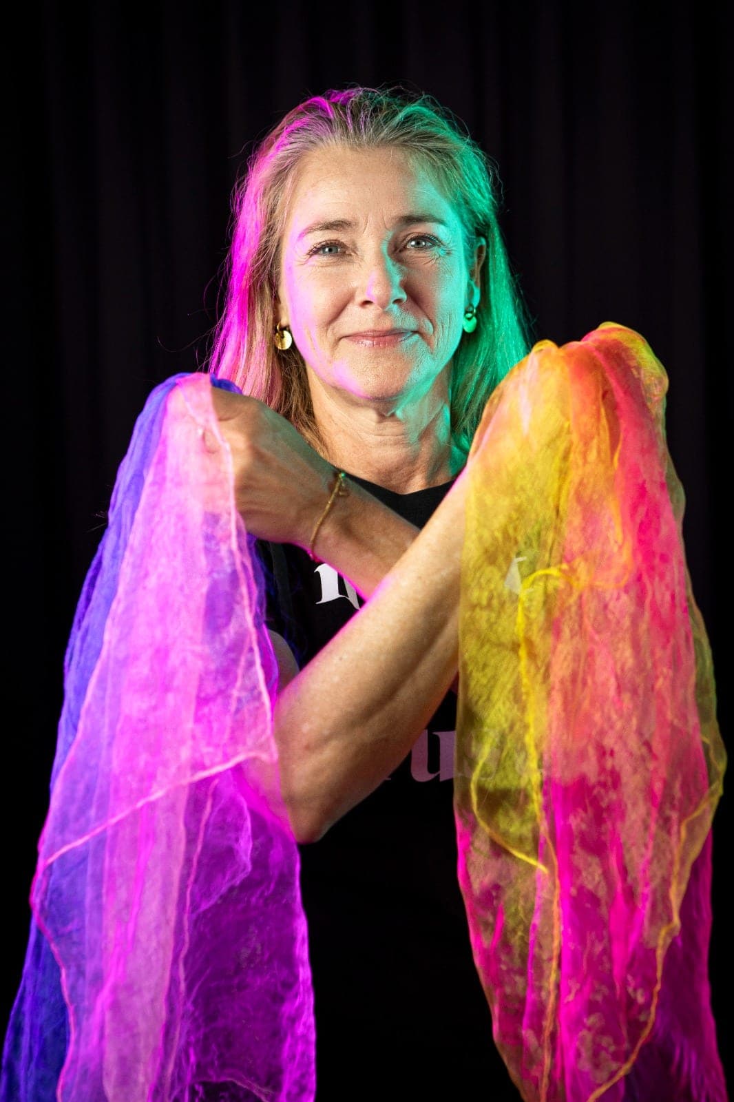 Dansdocent Helga Verrijp met haar armen gekruist vol kleurige sjaals