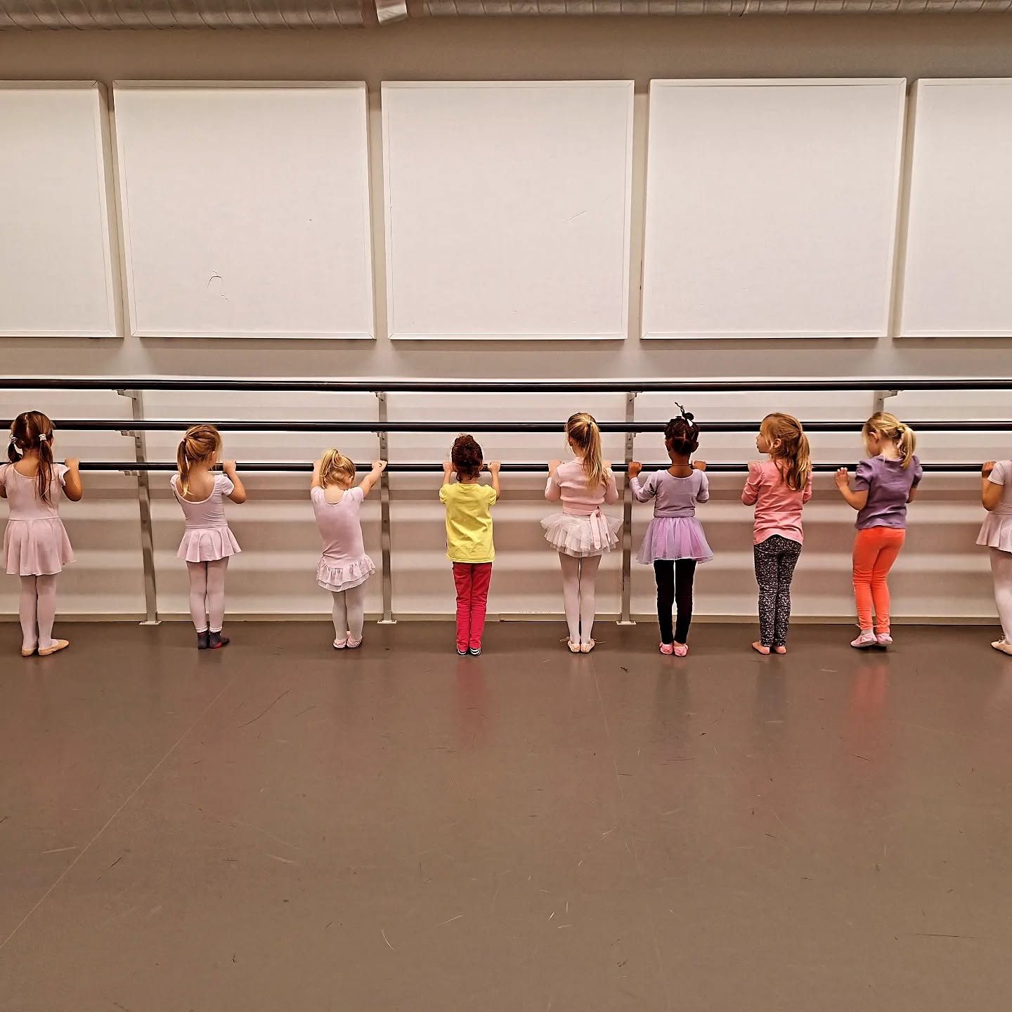 Kinderen oefenen bij de barre tijdens balletles